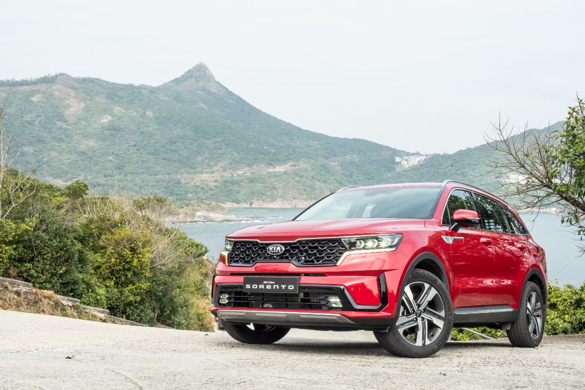 Front view of red kia sorento with mountain background.