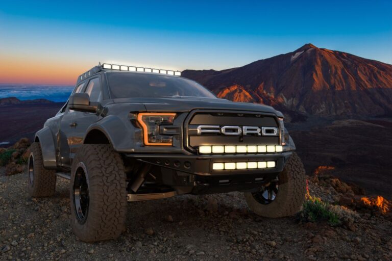 The all new Ford 150 in a black colorway parked in mountain terrains.