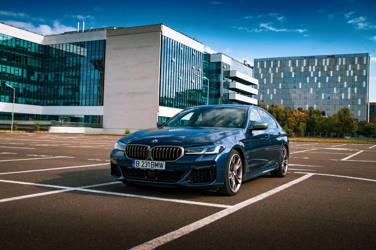 A photo of brand new car bmw 5 series alone in praking space.