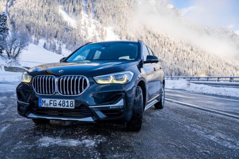 Close up photo of bmw x1 car parked in the middle of road during winter with beautiful background.