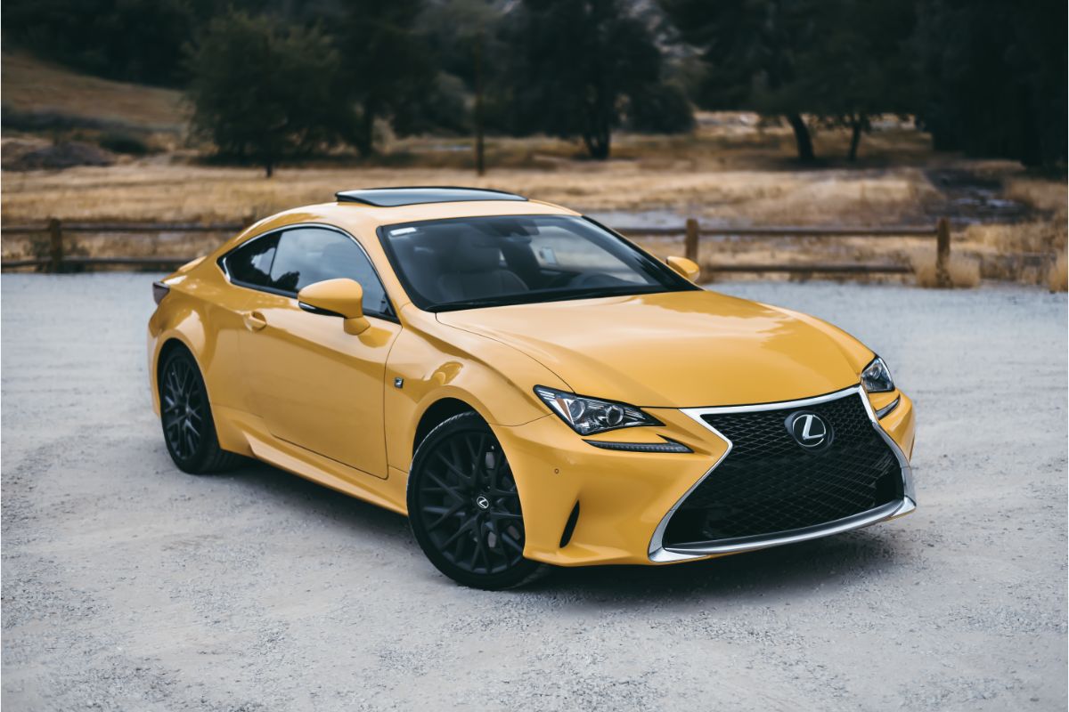 A photo of lexus rc f car in yellow color photographed infront of mountain.