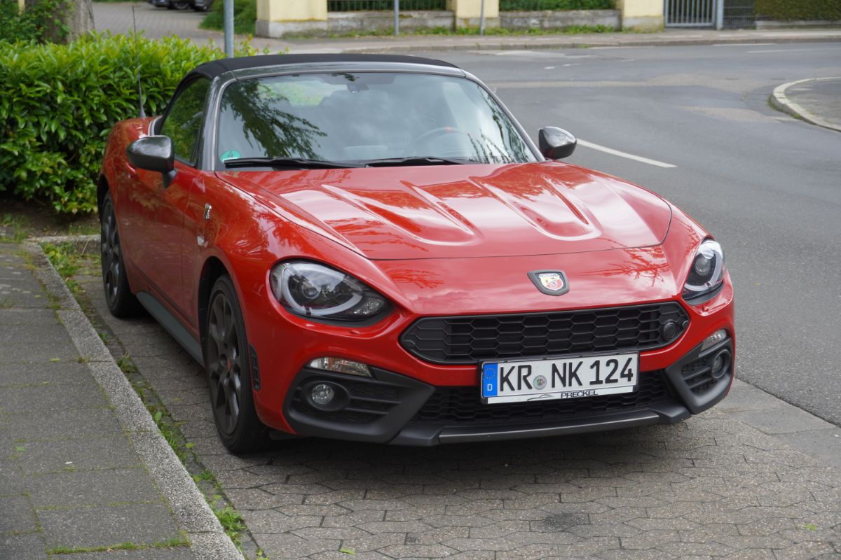 A red fiat 124 car parked at the side street.