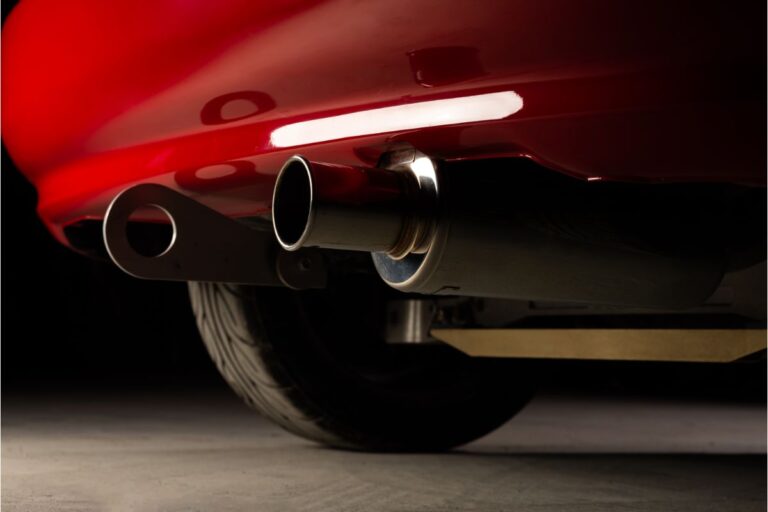 Close up photo of red car exhause pipe.