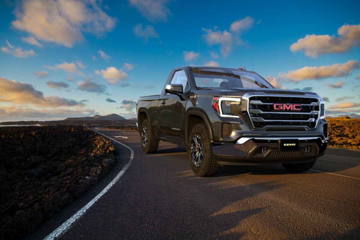 The 2021 GMC Sierra a light duty truck captured driving by in a country road.