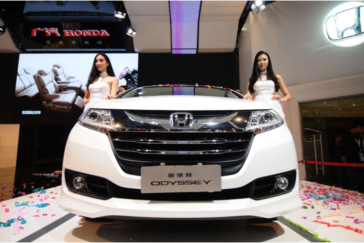 Brand new white Honda Odyssey in an automobile exhibition in China with two beautiful models.