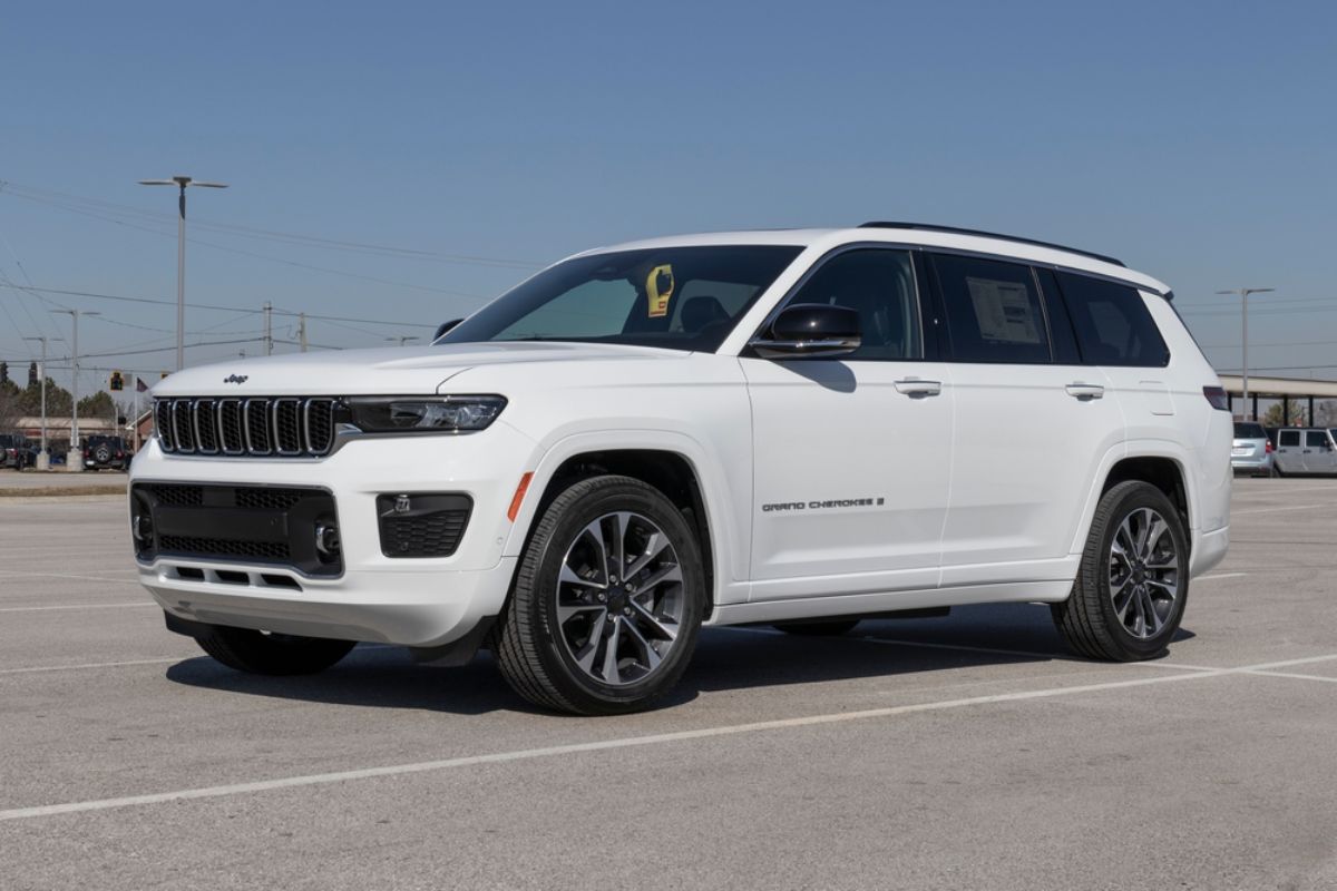 Jeep Grand Cherokee in a white colorway 2022 model parked outside in a big space.