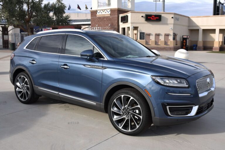 Side view photo of Lincoln Nautilus car in blue color displayed outside.