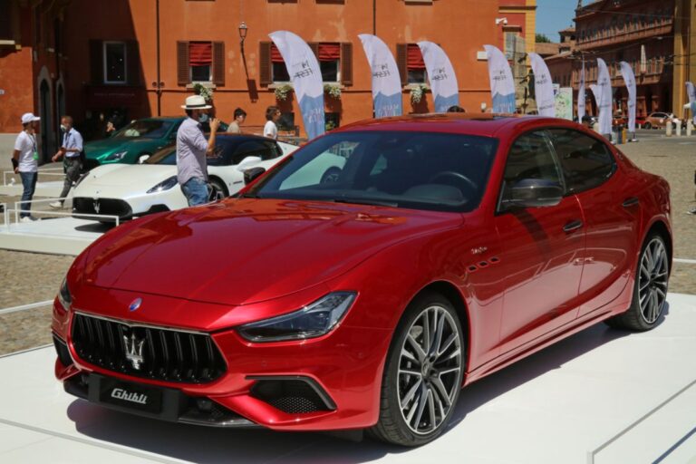 Maserati Ghibli in a red colorway parled outdoors at the street in Modena Italy.