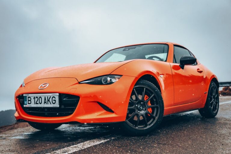 A photo of orange mazda mx 5 photographed on the street.