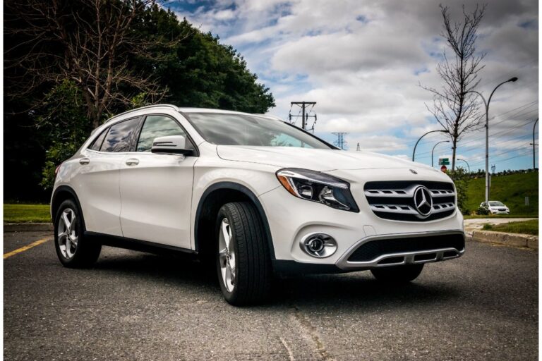 Side view photo of white mercedes benz gla 250 car in the middle of road.