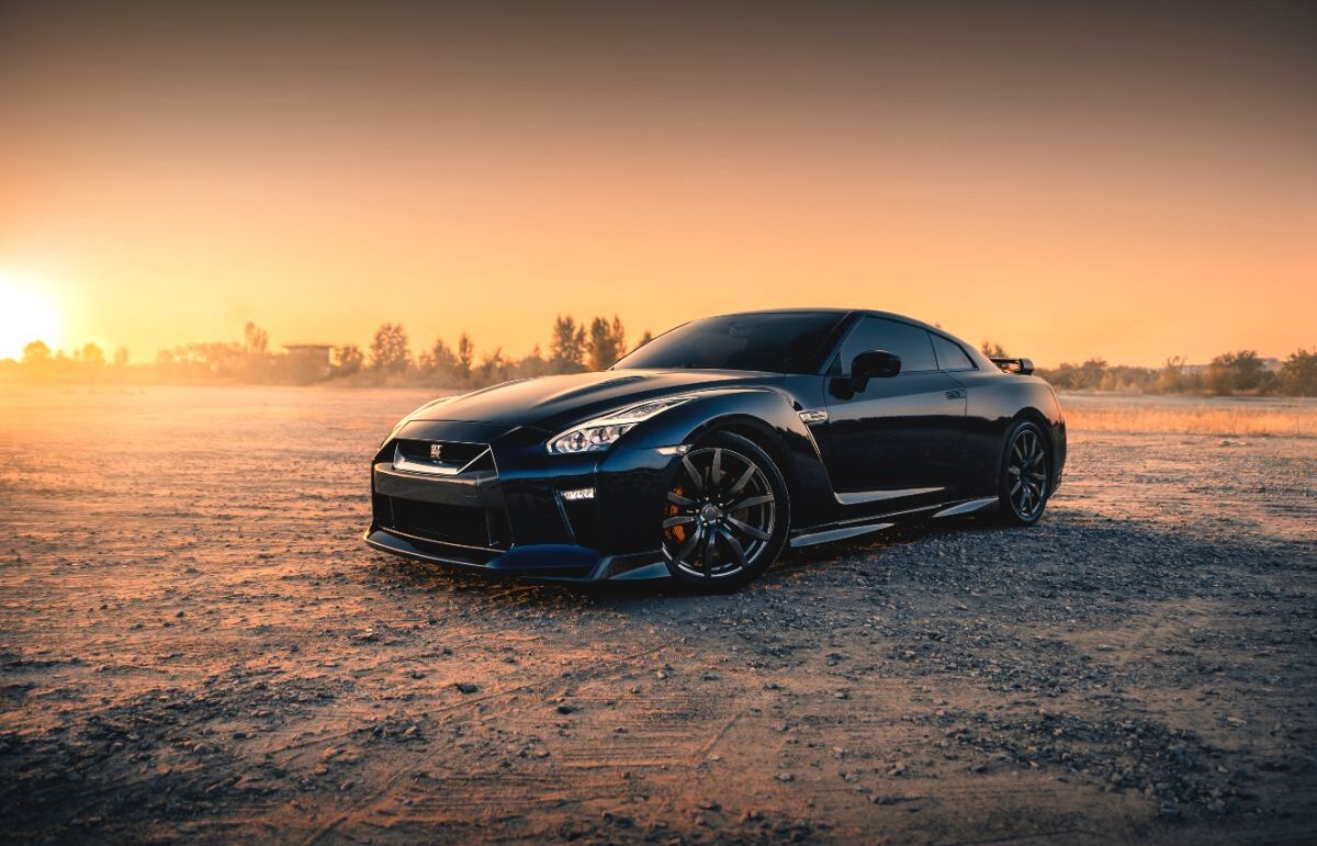 Side view photo of black nissan gt r in the sunset.