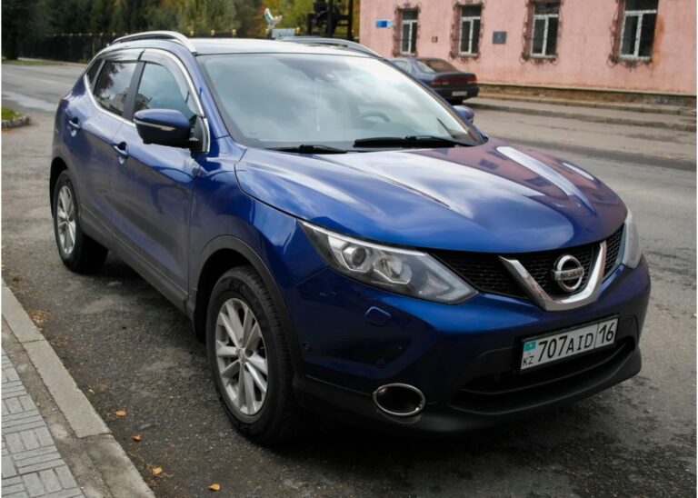 Blue Nissan Quashqai compact crossover parked beside the street somewhere in the city of Kazakhstan.