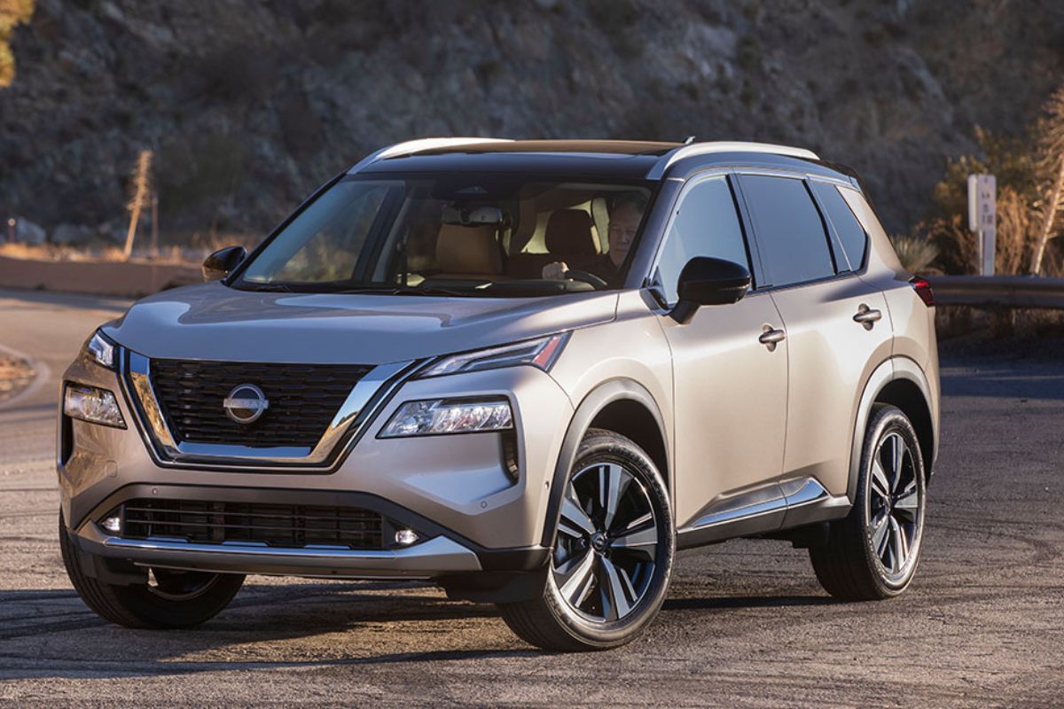 Brand new 2022 model of a Nissan Rogue in a gray colorway in a photoshoot in a rocky side road for featuring.