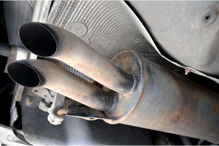 A semi old and diry dual car exhaust pipe muffler.