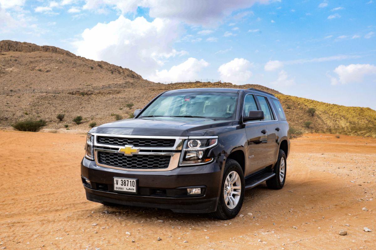 Chevrolet Suburban in a black colorway parked at the Sahara Desert in Dubai.