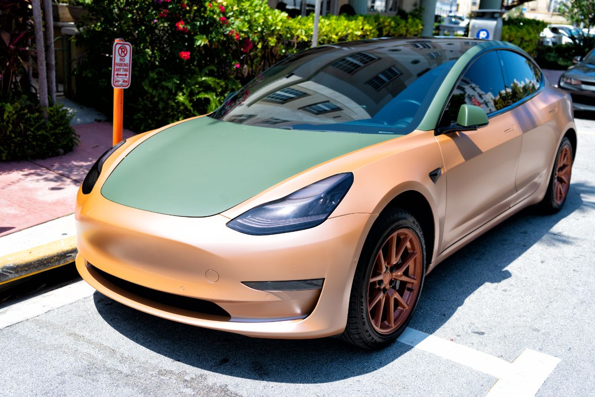 Matte black and orange Tesla Model Y parked in the street of Miami, Florida.