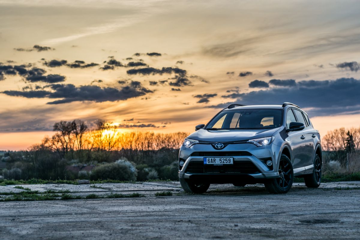 A photo of toyota rav4 parked outside with sunset view.