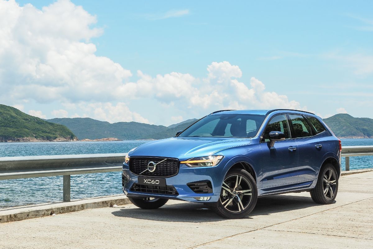 Front and side photo of blue volvo xc60 photographed at seaside.