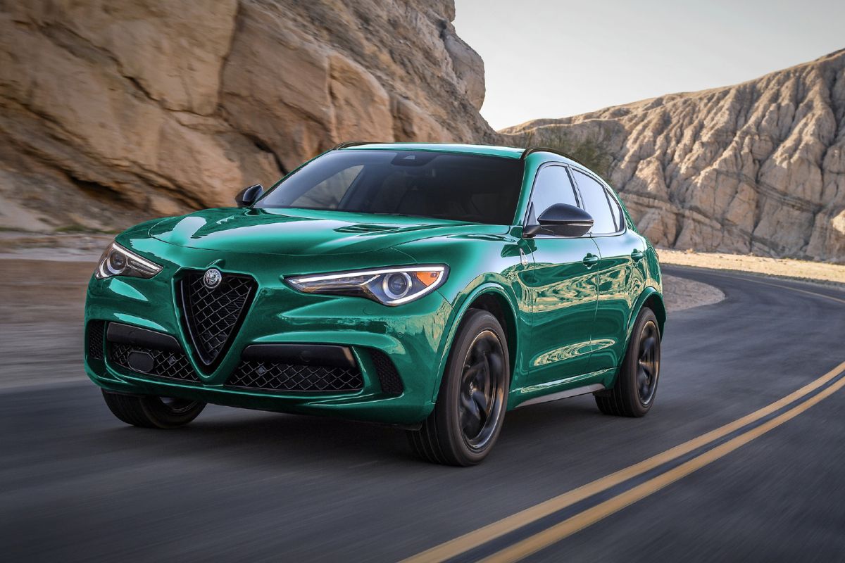 A green 2022 Alfa Romeo car moving on the road at the desert place.