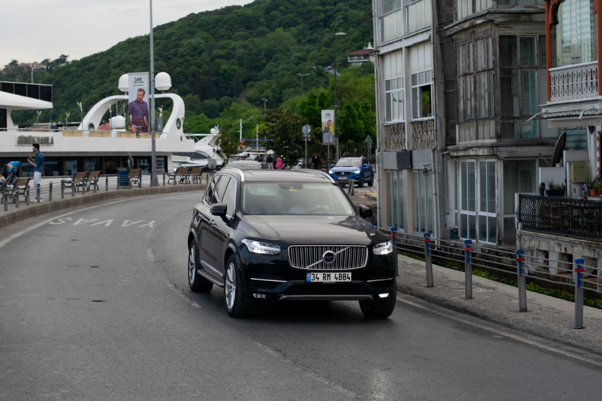 A picture of black vovlo xc60 at the city street in motion.