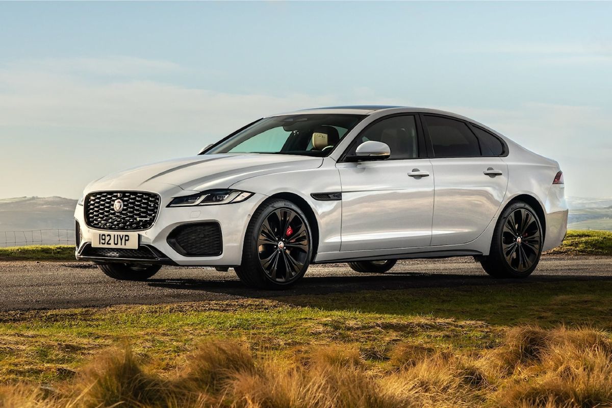 Side view shot of white 2023 Jaguar XF car on the grass.