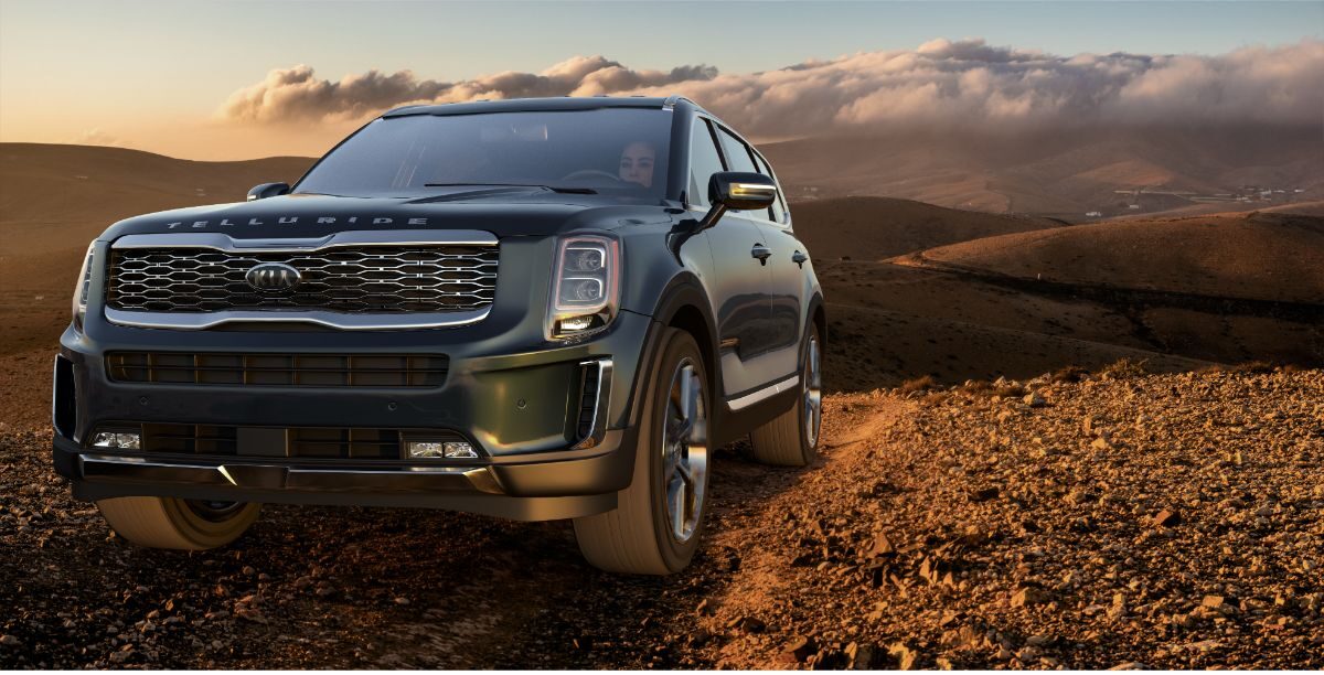 Front side view angle of the all new 2023 mode Kia Telluride in gray colorway with a lady driver.