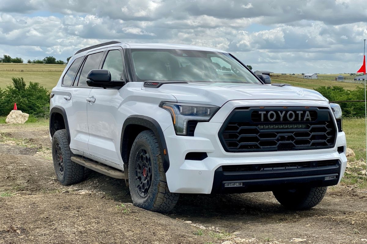 A white 2023 Toyota Sequoia car driving at the countryside with nature view.