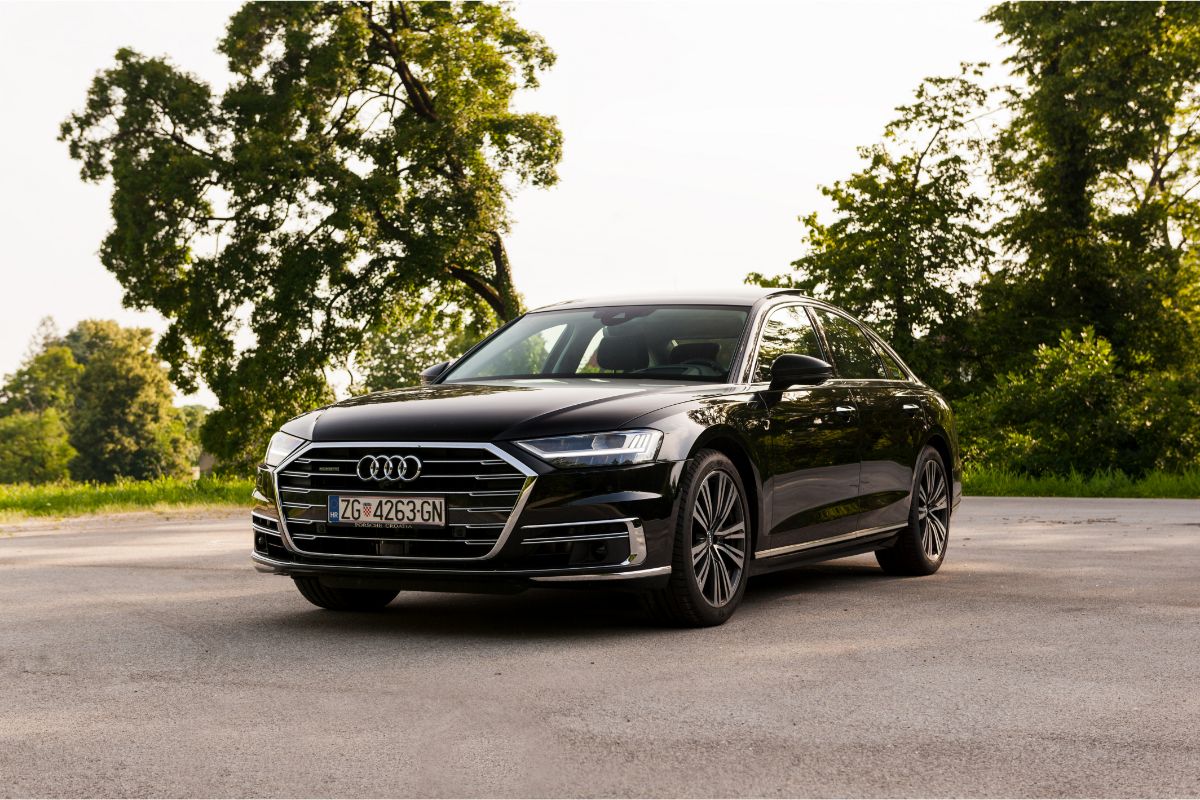 A photo of black Audi A8 car parked outside at the city street.