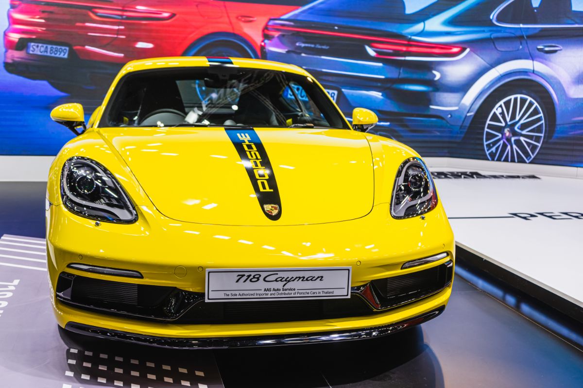 Front view of a yellow Porche Cayman 718 on display.