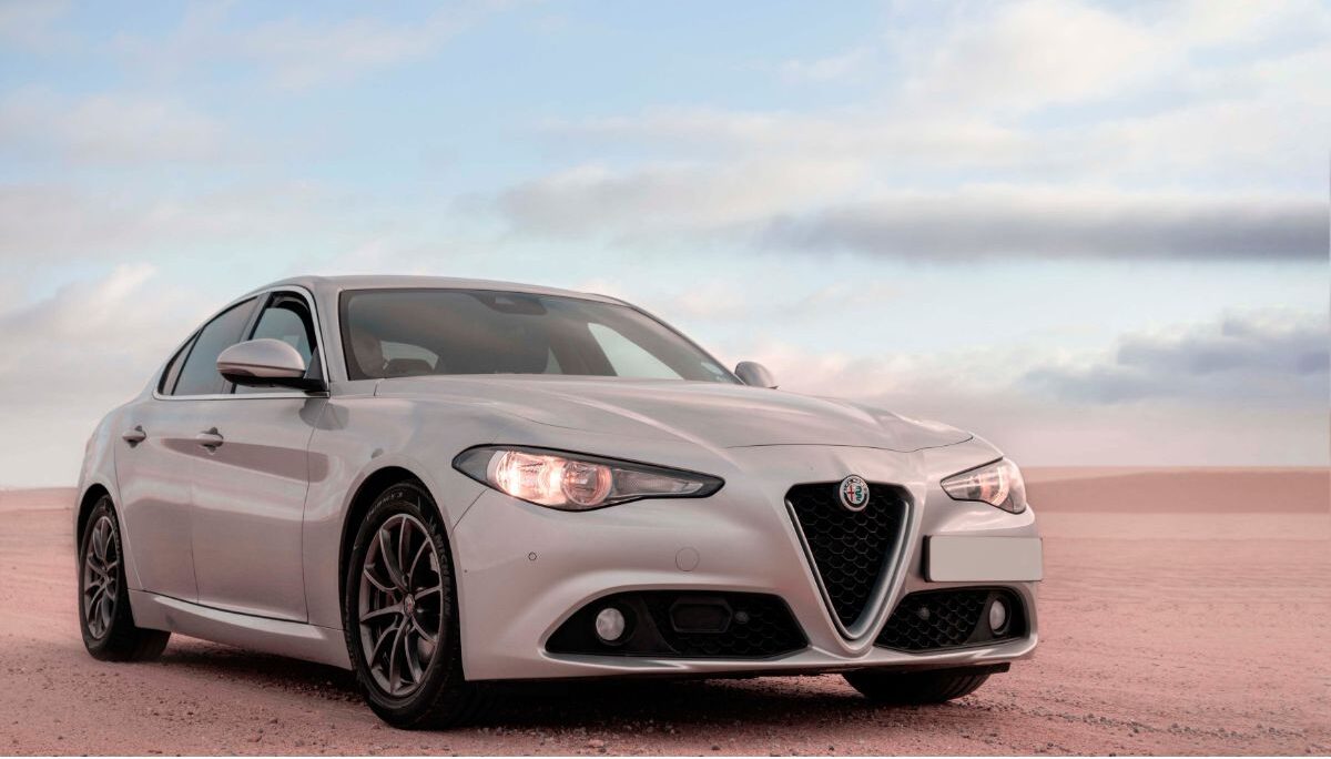 Front view of white Alfa Romeo Giulia standing in the middle of the desert.