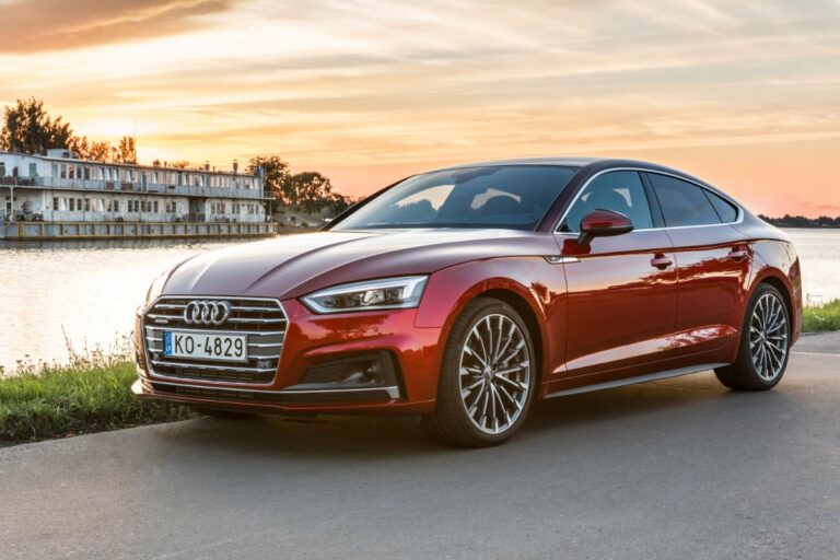 New Audi A5 car in a red color photographed near river on sunset background.