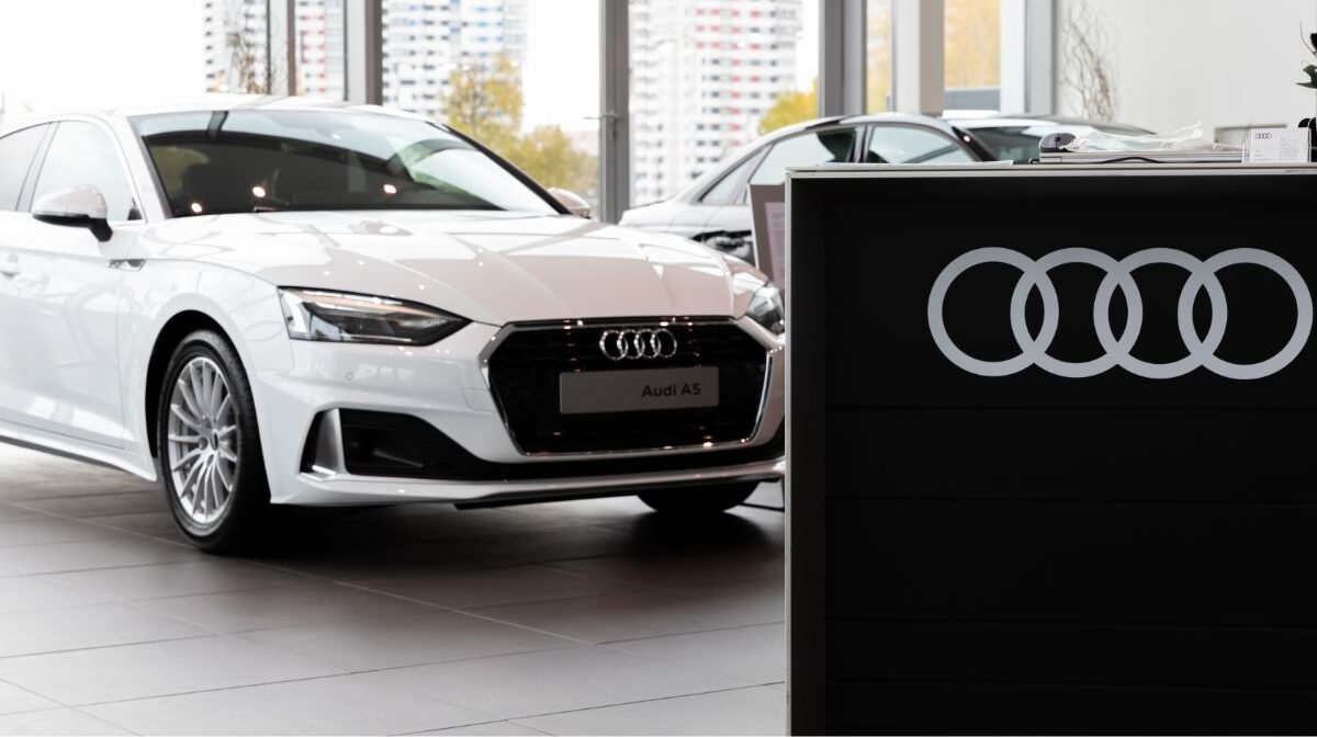 A brandnew white Audi A5 in a dealer showroom.