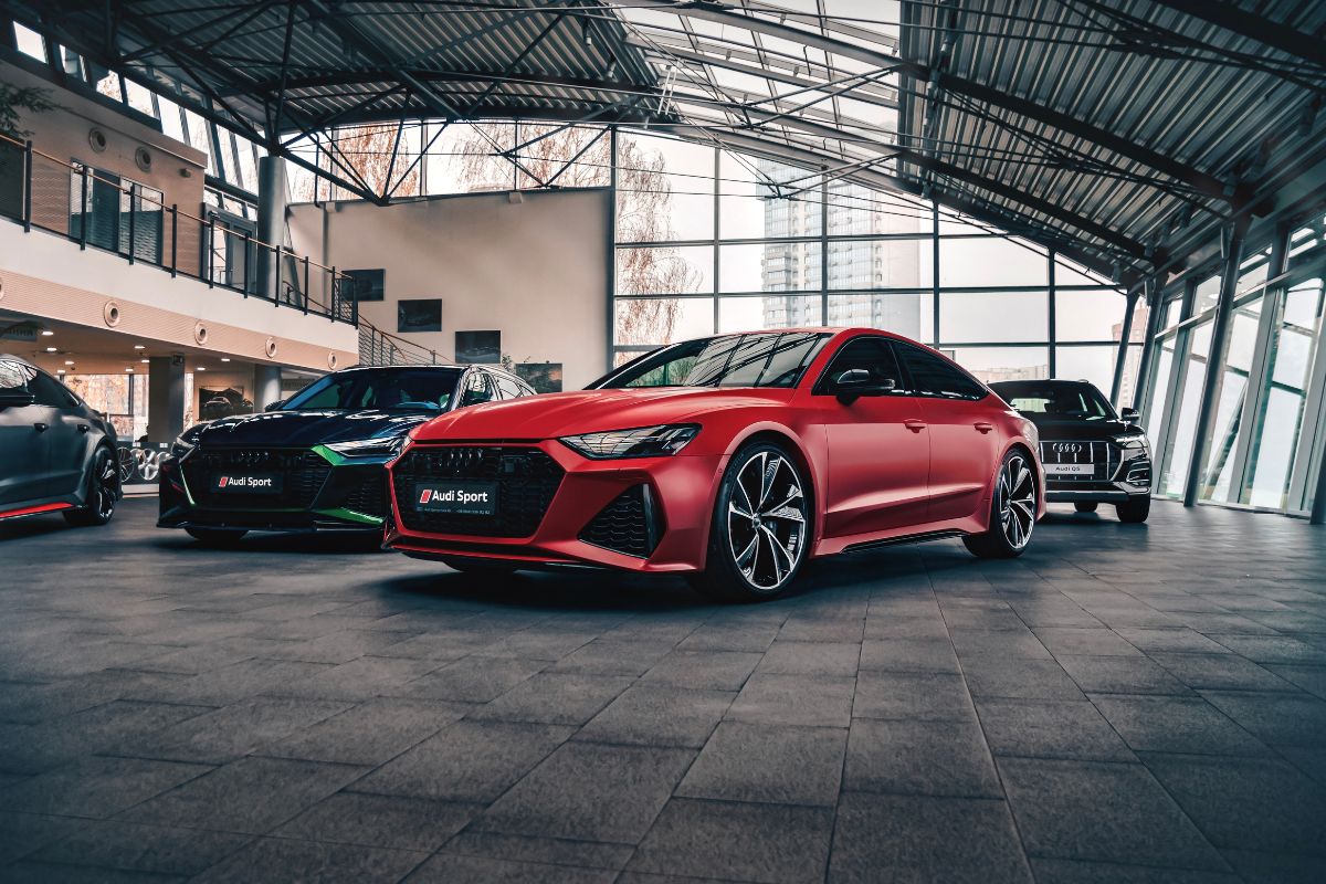 New Audi RS7 at a photoshoot with other vehicles in red.