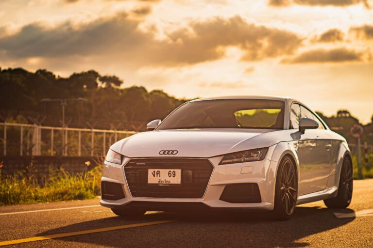 Daytime view of an Audi TT MK3 on an asphalt city road near an airport.