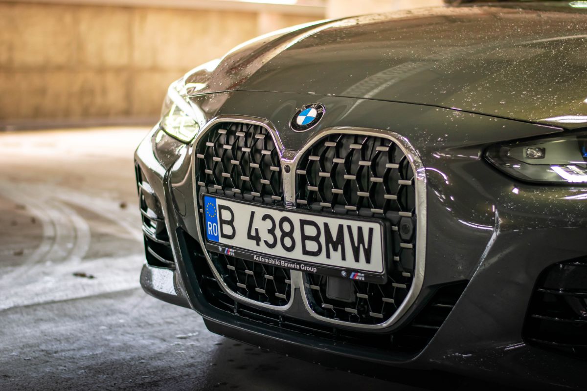 Close-up photo of a wet hood of a black BMW 4 Series.