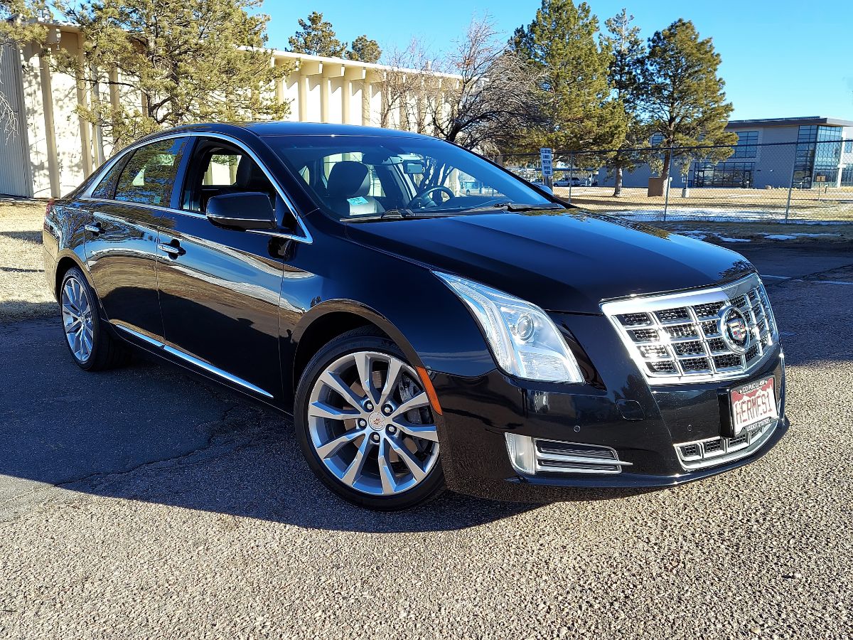 Front side view of a black Cadillac XTS parked.