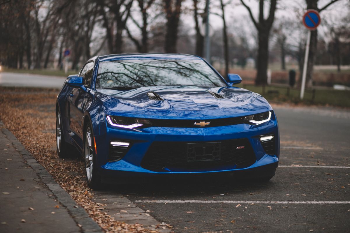 Gleaming blue Chevrolet Camaro SS parked at autumn.