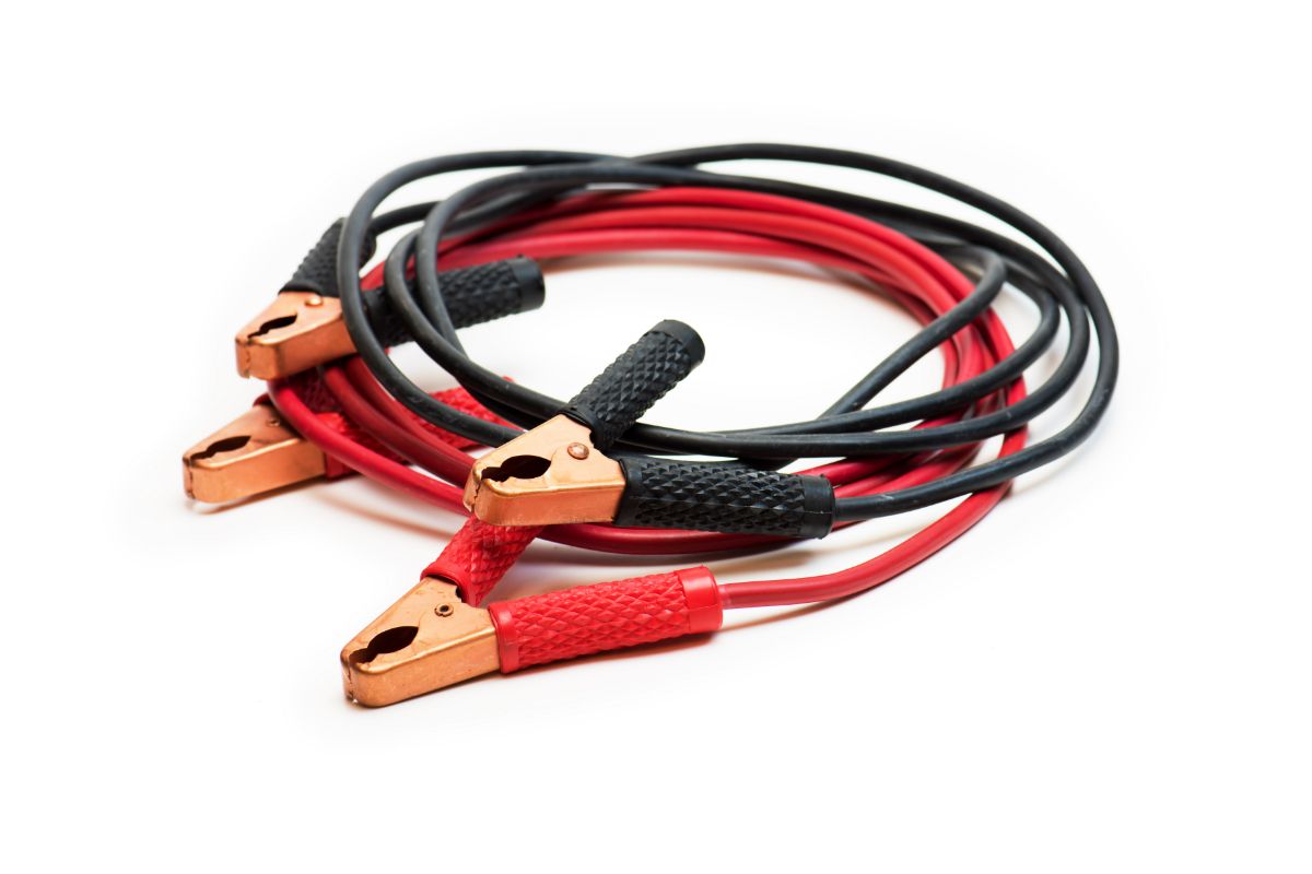 Car battery booster cables in red and black, isolated on white.