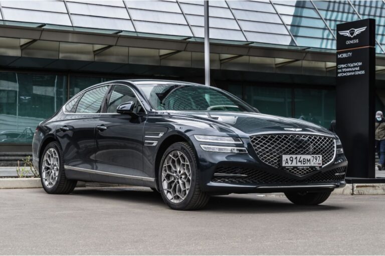 Side and front views of a luxury car, the Genesis G80, parked close to the commercial district.