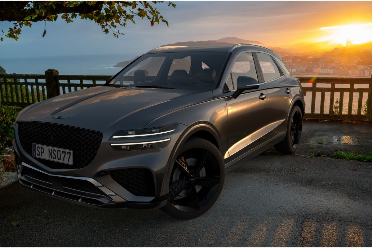 Close up photo of black Genesis GV70 car parked with a sunset view.