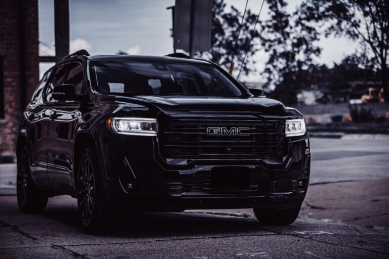 Side view angle of a brand new GMC Acadia in all black colorway parked outdoors in Omaha, Nebraska.