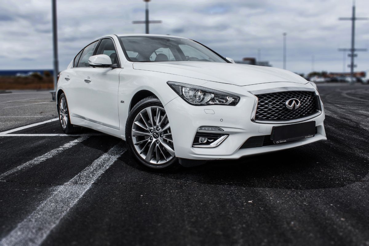 A white Infiniti Q50 in the parking lot.