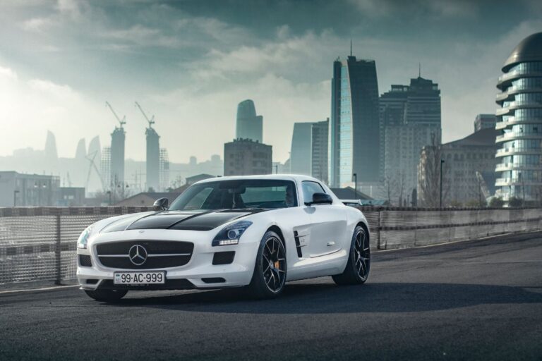 A photo of Mercedes Benz AMG GT  car driving at the road with a city as a background.