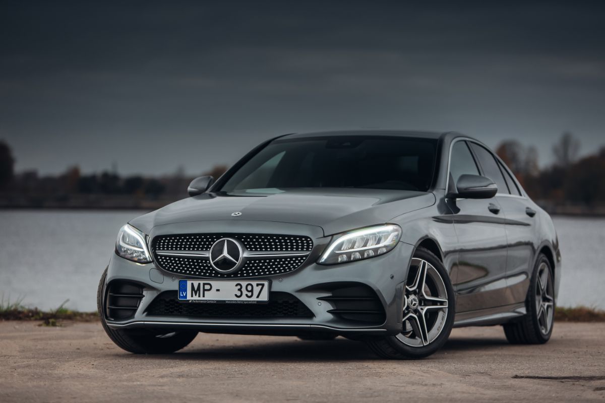 Front view of a gleaming Mercedes Benz C Class parked near the river.