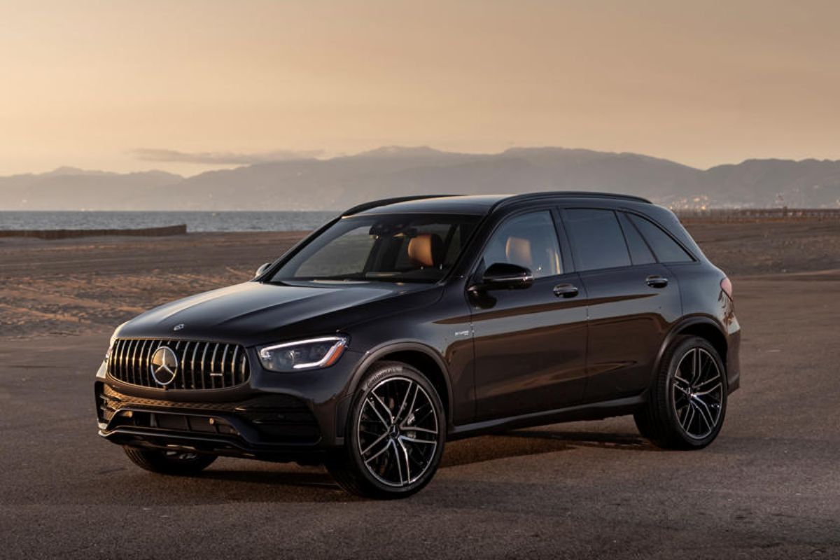 Side view angle of the brand new 2022 model of the Mercedez AMG GLC in metallic black colorway with mesmerizing sunset background.