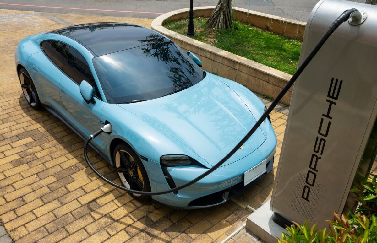 High angle from above of blue porsche taycan charging.