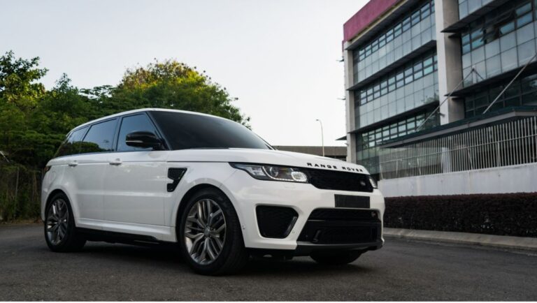 Side view angle of the a white colorway Range Rover Velar parked outdoors.