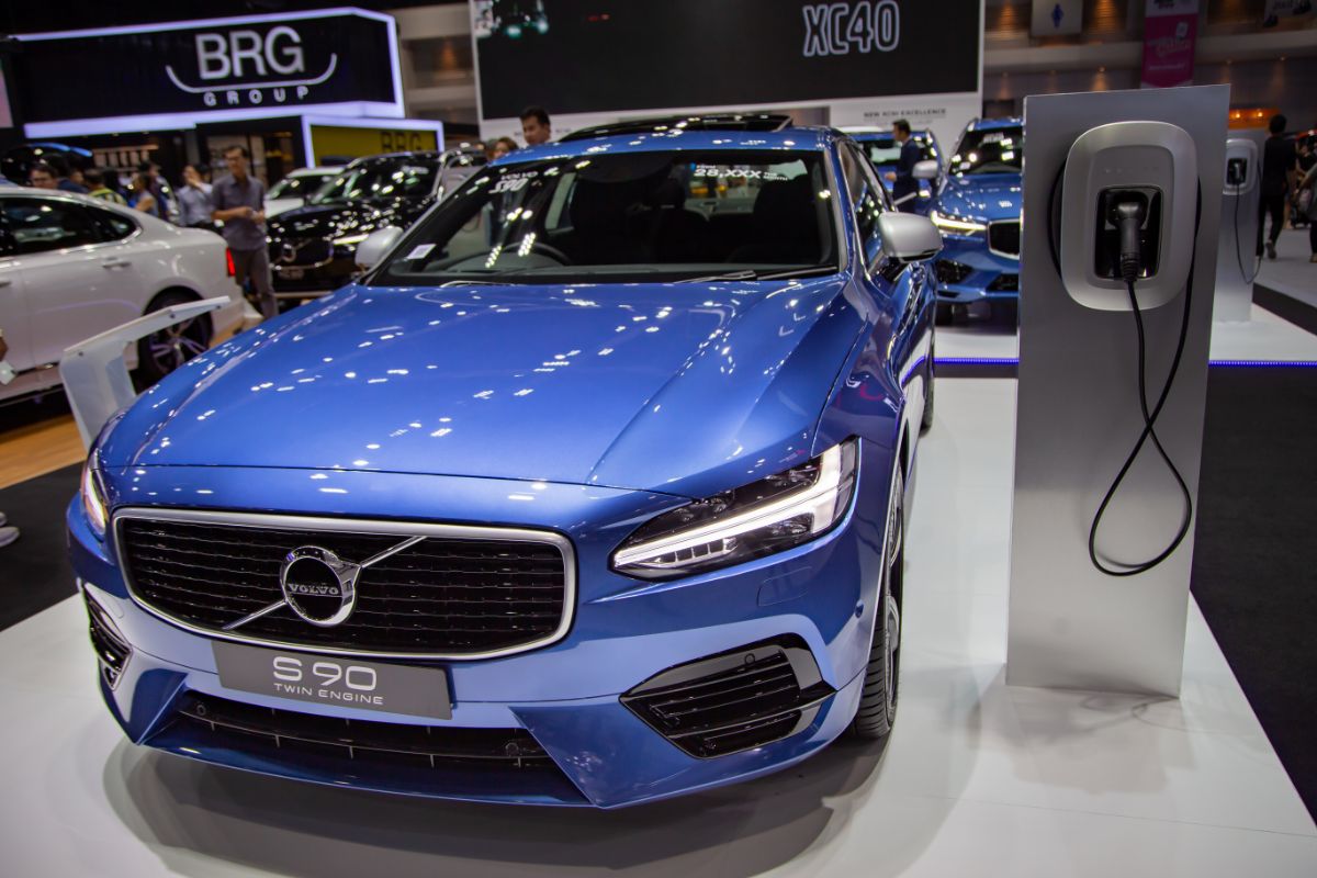 Close up look of Volvo S-90 in a blue color charging at the auto show.