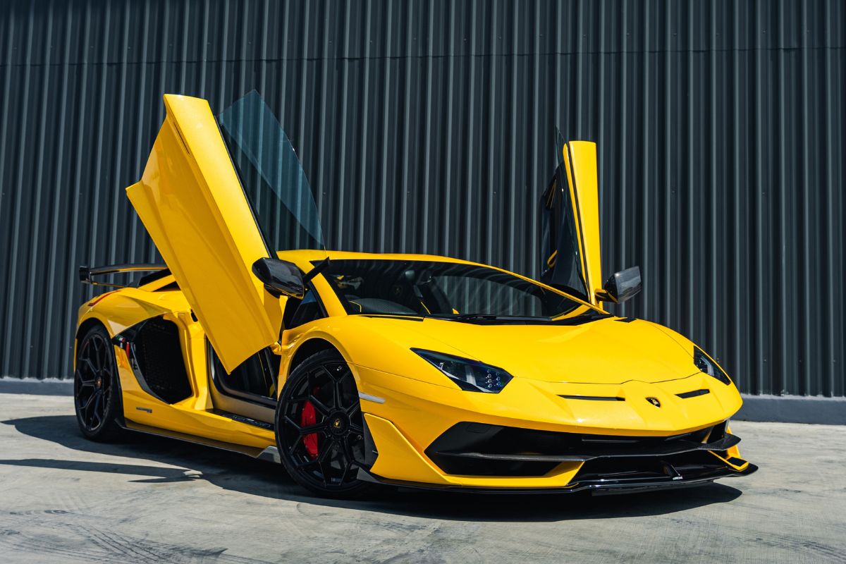 Full view of a yellow Lamborghini Aventador that is parked on a city street.