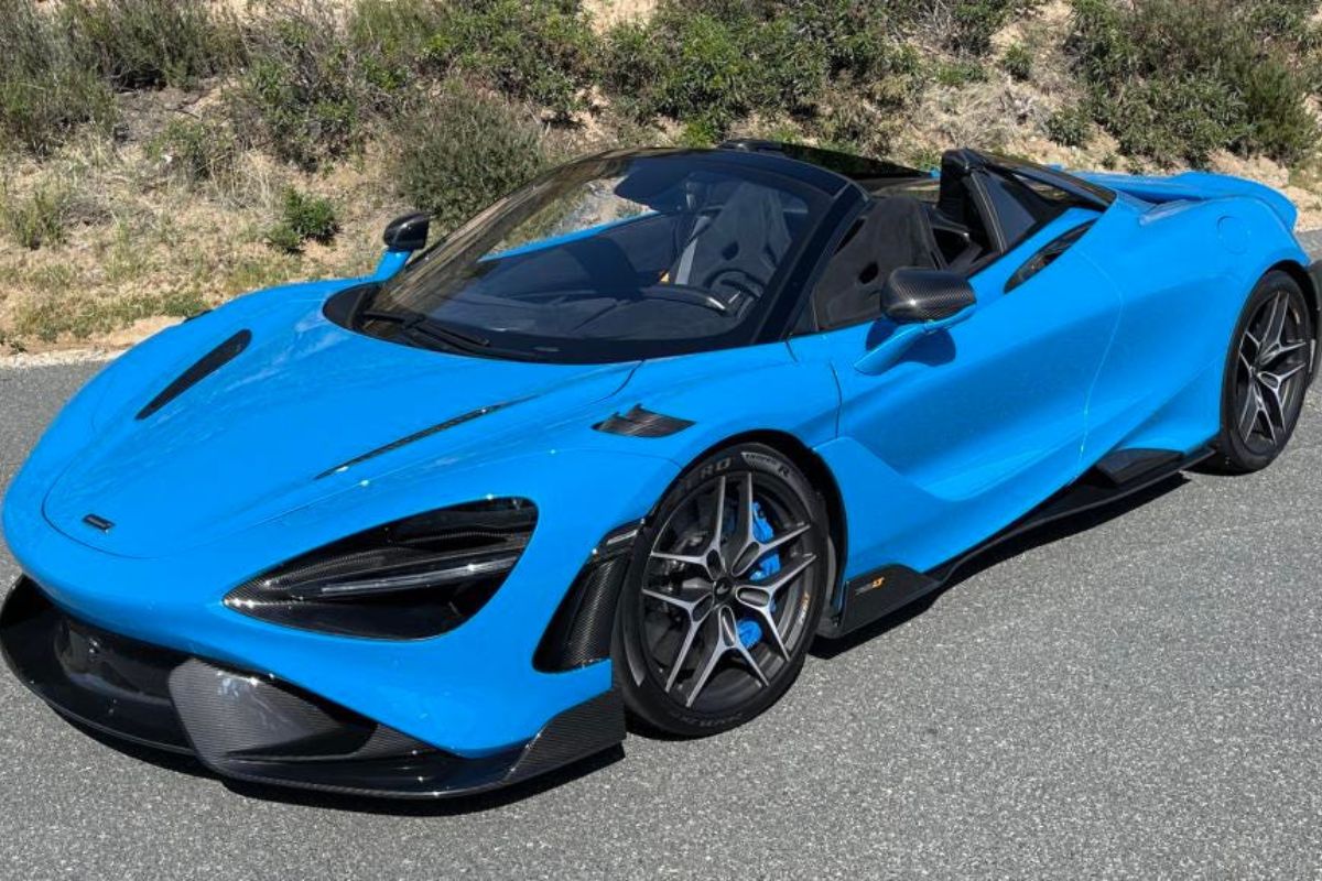 Full shot of a blue 2022 McLaren 765LT Spider sports car on the road.